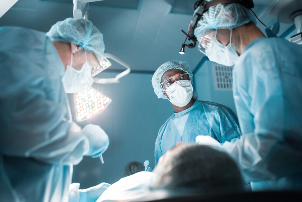 bottom view of multicultural surgeons operating patient in operating room